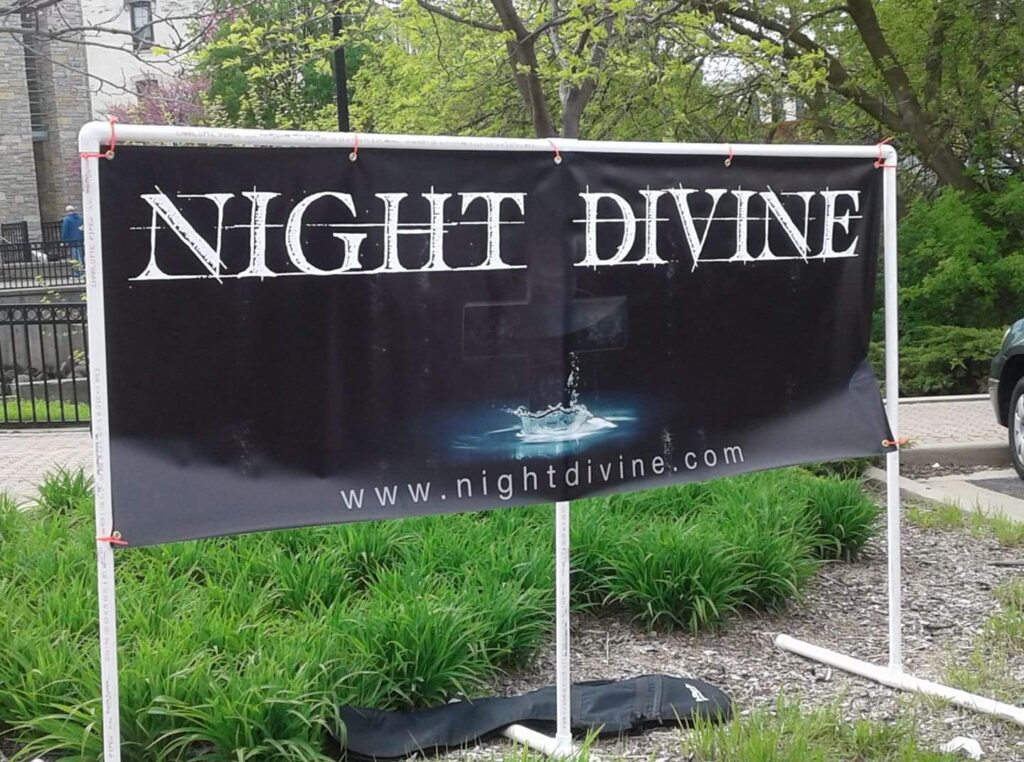 The Night Divine banner is displayed at a concert